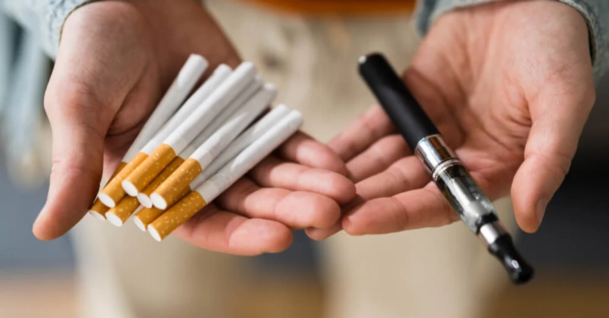 two hands with cigarettes in one and an e-cigarette in the other