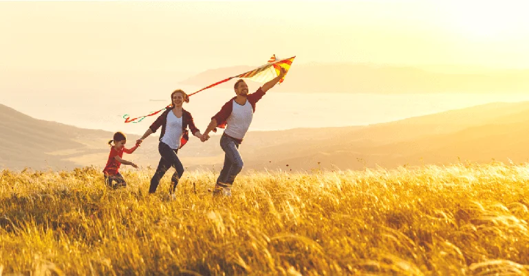 A happy family of 3 flying a kite