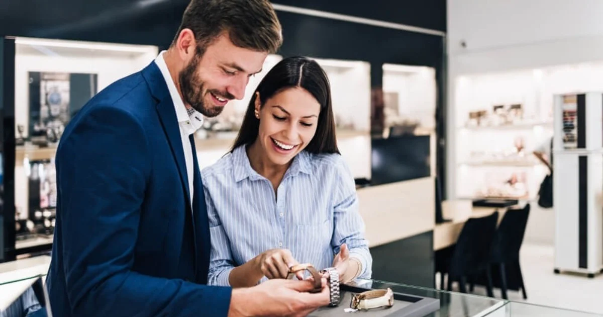 a young couple looking happy buying a watch