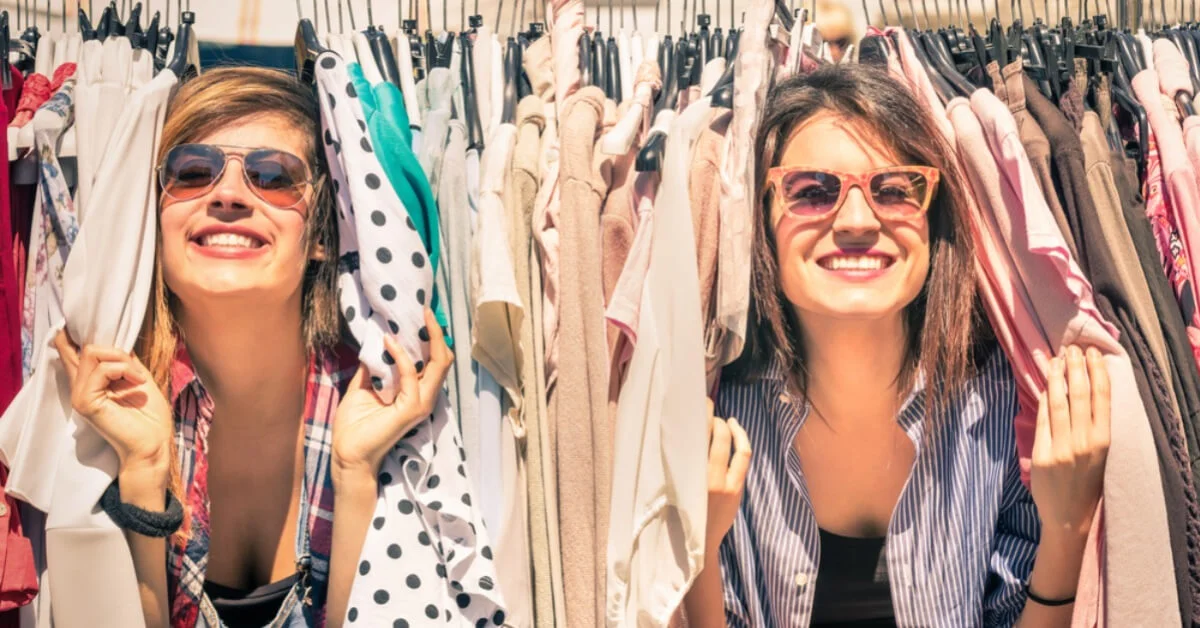 young women happy looking through a clothing rail
