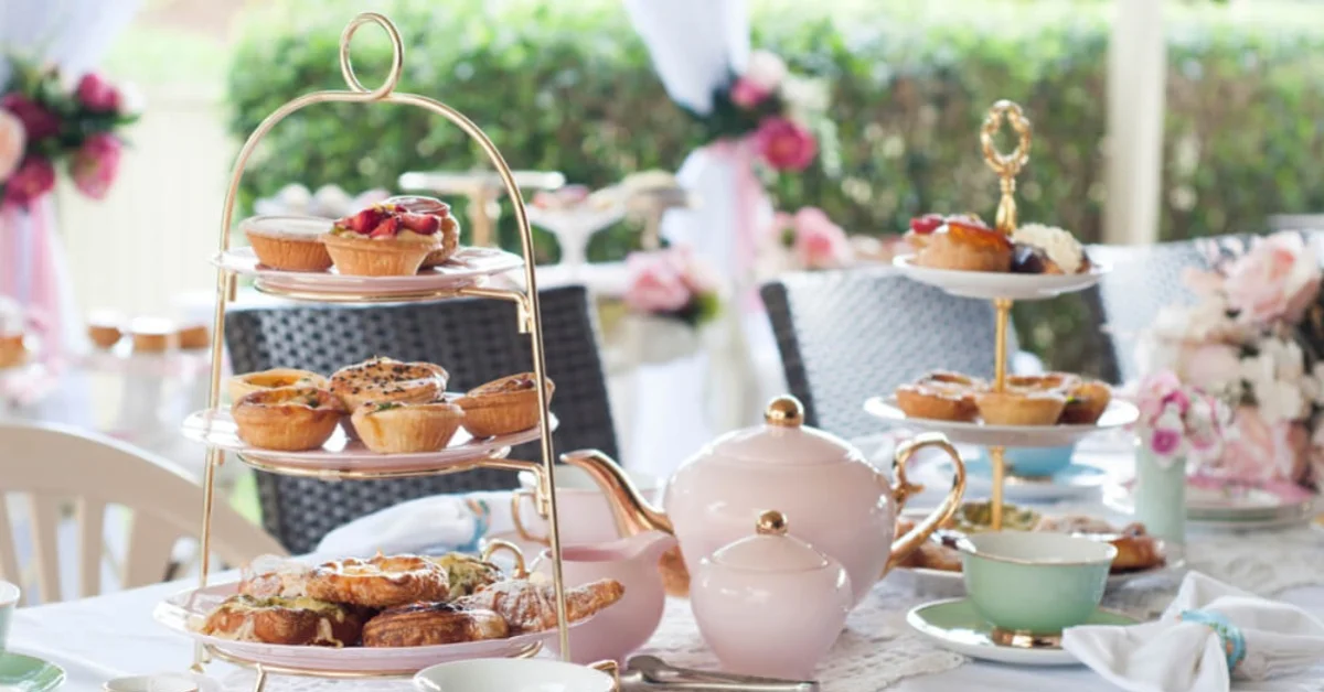 afternoon tea party on a table with cakes and sandwiches