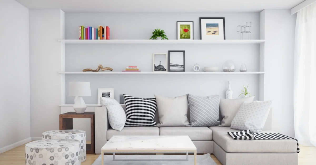 a white, modern living room with a sofa and floating shelves on the wall