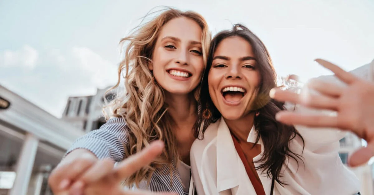 two young women smiling looking into the camera
