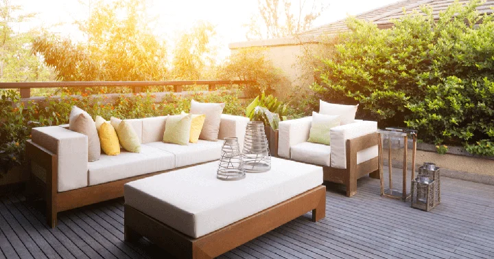 Tidy garden furniture sat on decking with the sun setting in the background