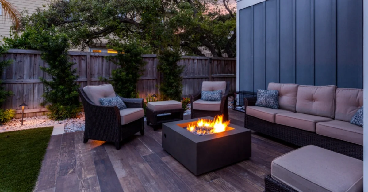 a fire pit in a garden with comfy sofas