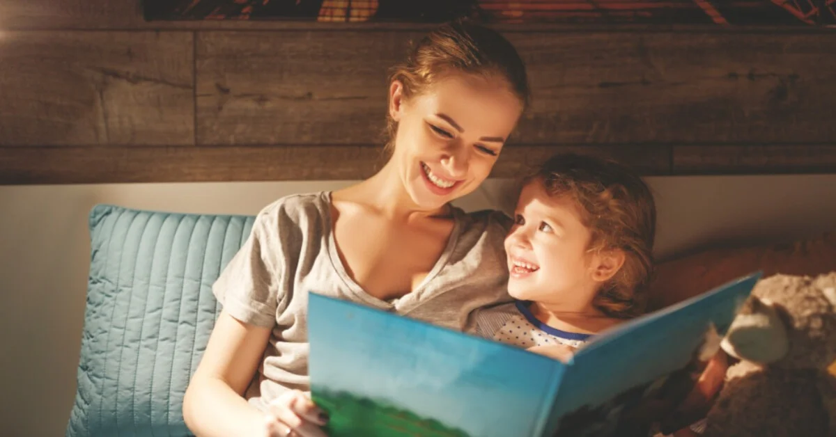 a mum smiling reading to her daughter