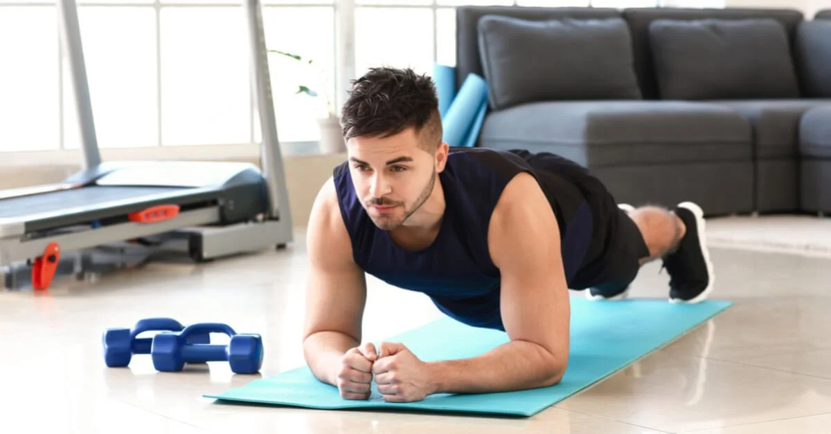 a sporty young man working out at home