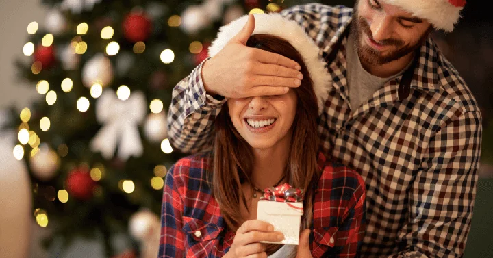 A happy wife or girlfriend receiving a surprise gift from her partner