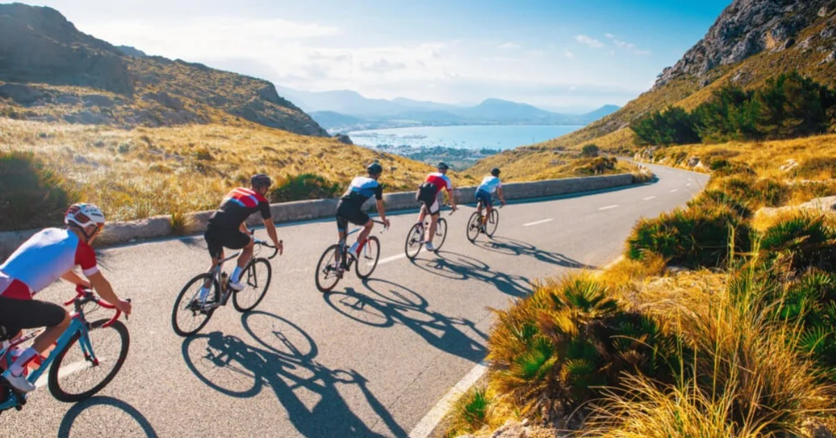 a group of people cycling along a mountain road