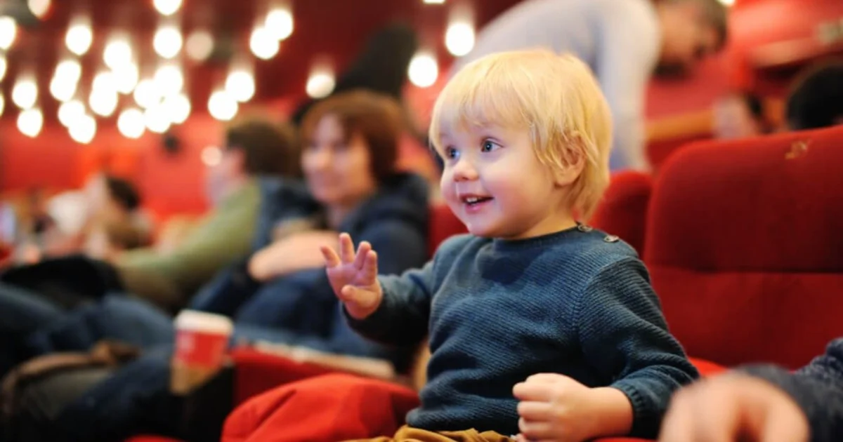 a young boy looking happy sat in the theatre
