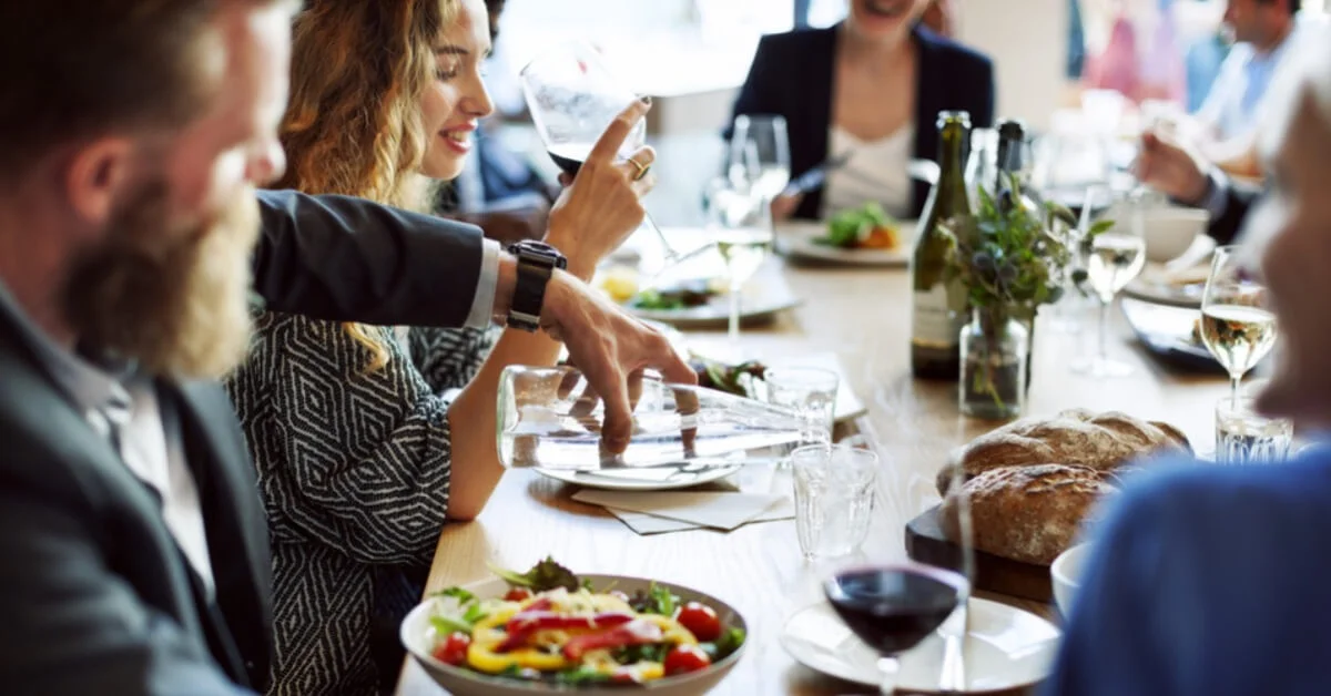a group of friends dining out with water and wine on the table