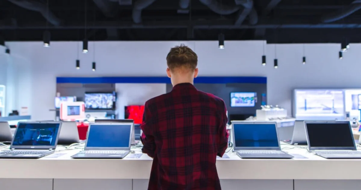 a man in a computer shop comparing different models