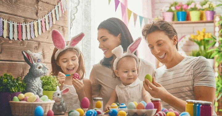 A family of four enjoying Easter decoration activities around a table
