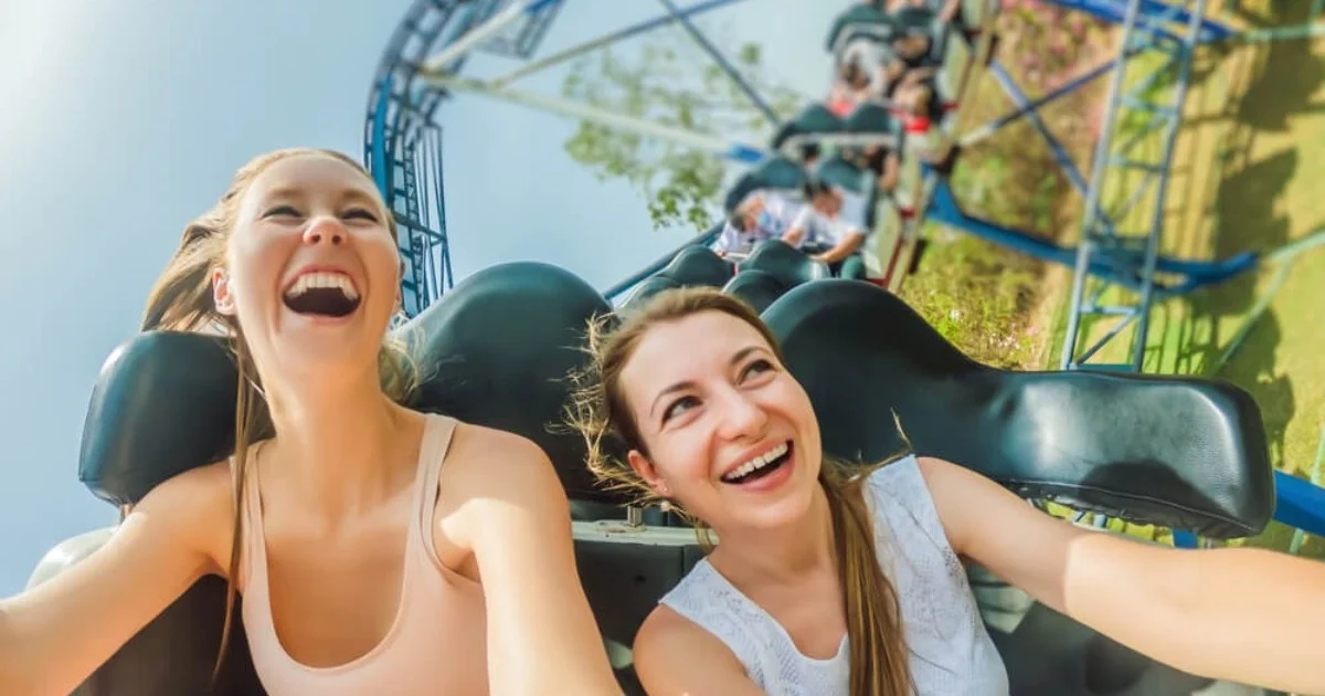 two young women laughing on a rollercoaster