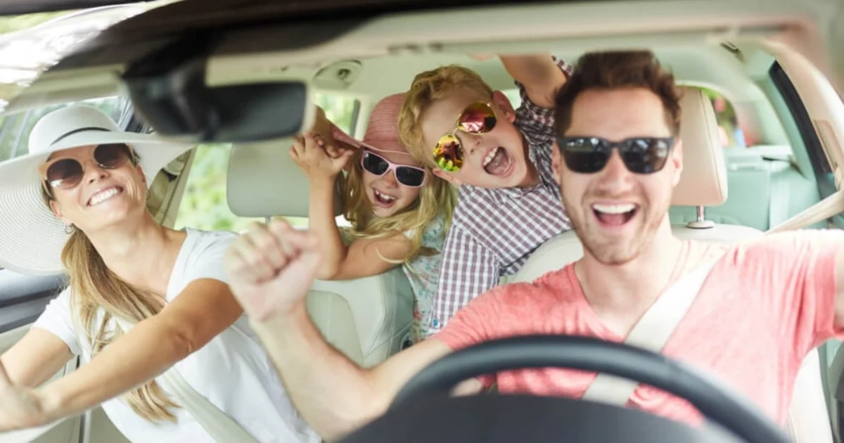 a family having fun driving in a car on holiday