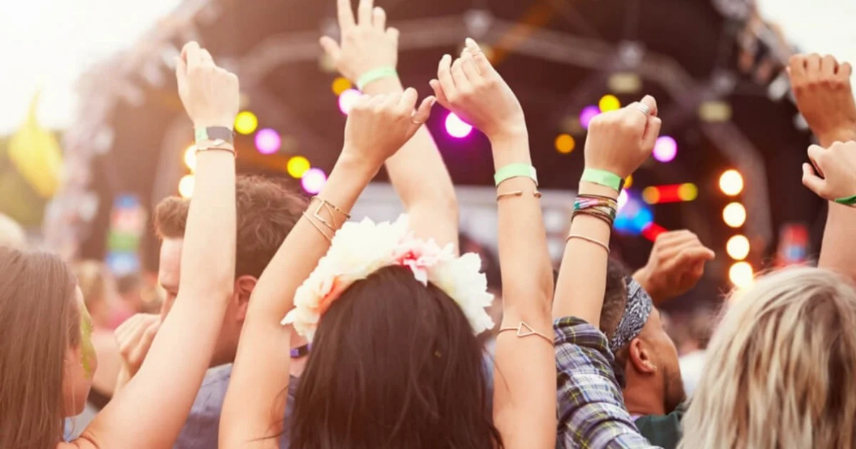 people with their hands up partying at a festival