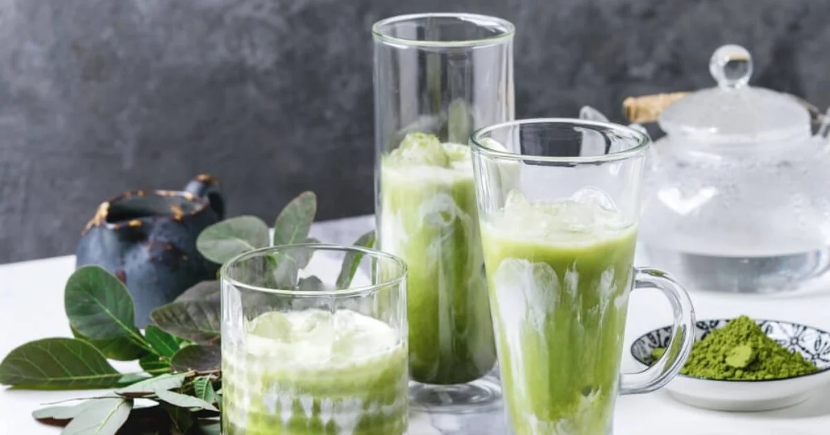 an array of different glasses filled with a green drink