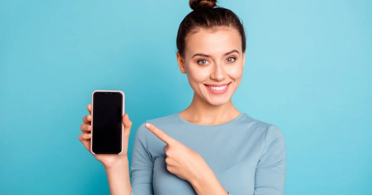 a young woman smiling holding a mobile phone