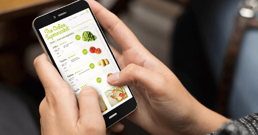 A woman grocery shopping on her phone