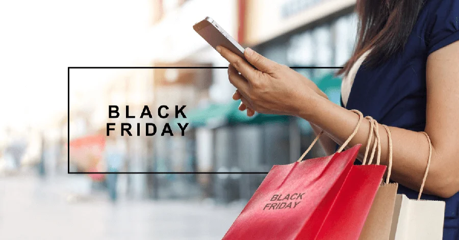A woman holding her phone with shopping bags around her wrist. Black Friday in text overlaying the image